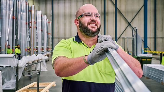 Male capral employee carying aluminium extrusion