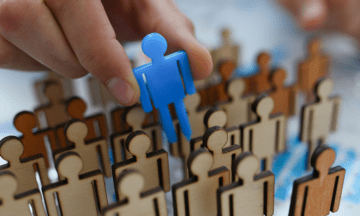 A picture of a blue stick figure being chosen compared to brown stick figures