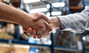 Two people handshaking in a warehouse