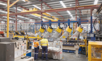 Two people controlling one of Capral's presses