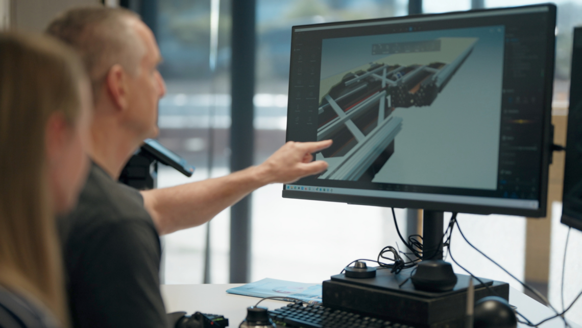 A photo of a ciltech staff member pointing at one of the pontoons designs