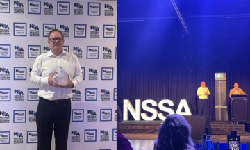 A picture of Anthony from GoldCo Security winning an award at the NSSA
