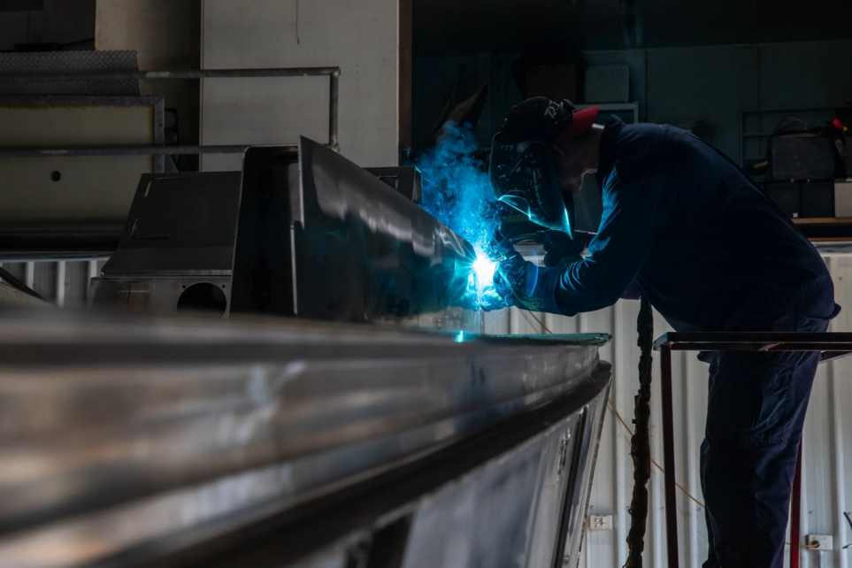 A photo of one of Custom works employees working on their aluminium boats